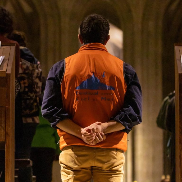 Image de bénévole au Mont Saint-Michel de dos dans l'Abbatiale